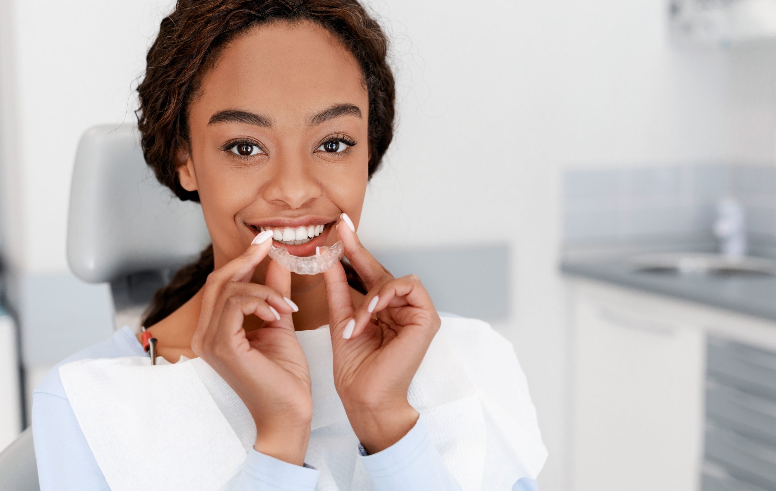 woman putting in her Invisalign aligners